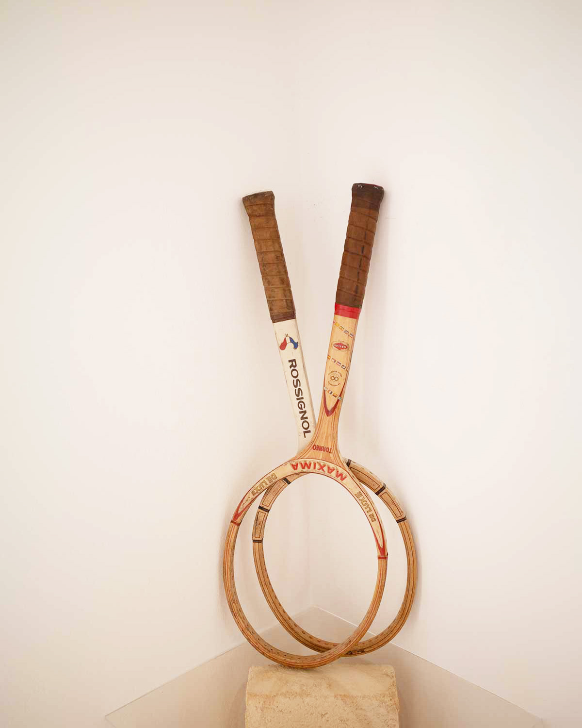 Dettaglio decorativo di Mae a Favignana con due racchette vintage in legno appoggiate in un angolo della casa.