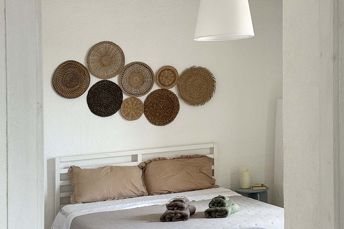 Camera matrimoniale tripla di Mae a Favignana vista dall’ingresso, con letto matrimoniale, panca ai piedi del letto e atmosfera luminosa.